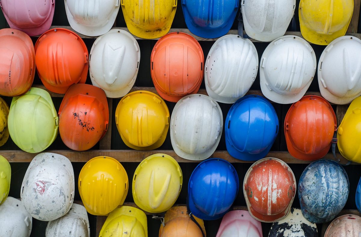 Cascos de seguridad de colores ordenados en un anaquel